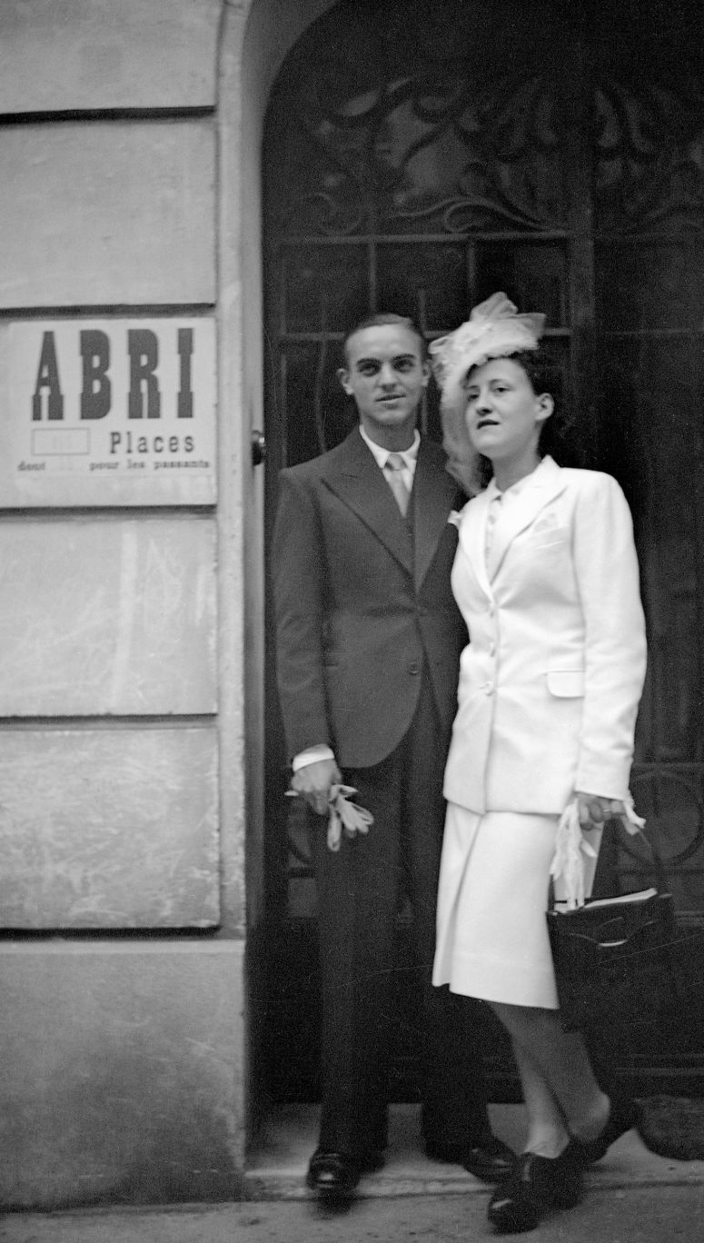 Mariés devant une porte d'immeuble.